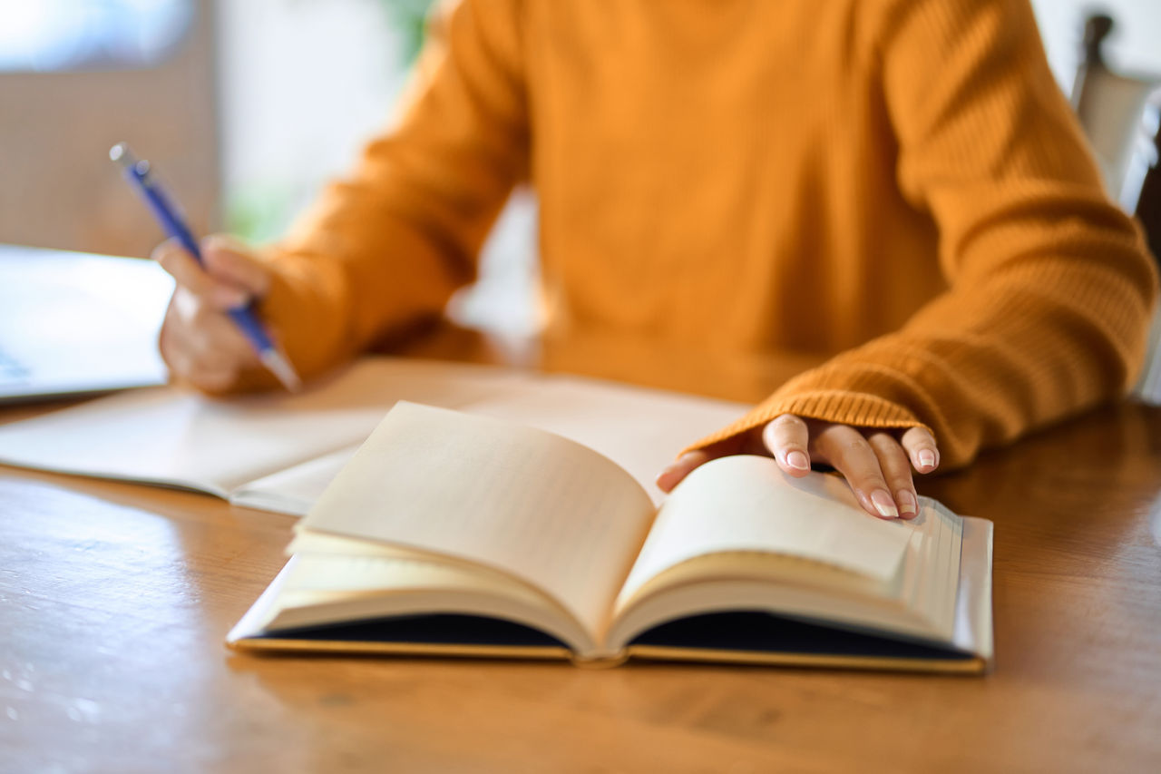 A woman reading a book and taking notes