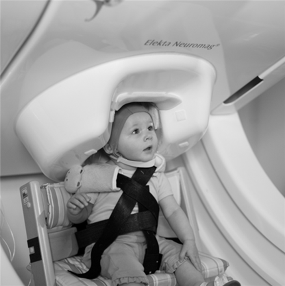 Figure 2.1. An 11-month-old infant being tested in the MEG machine